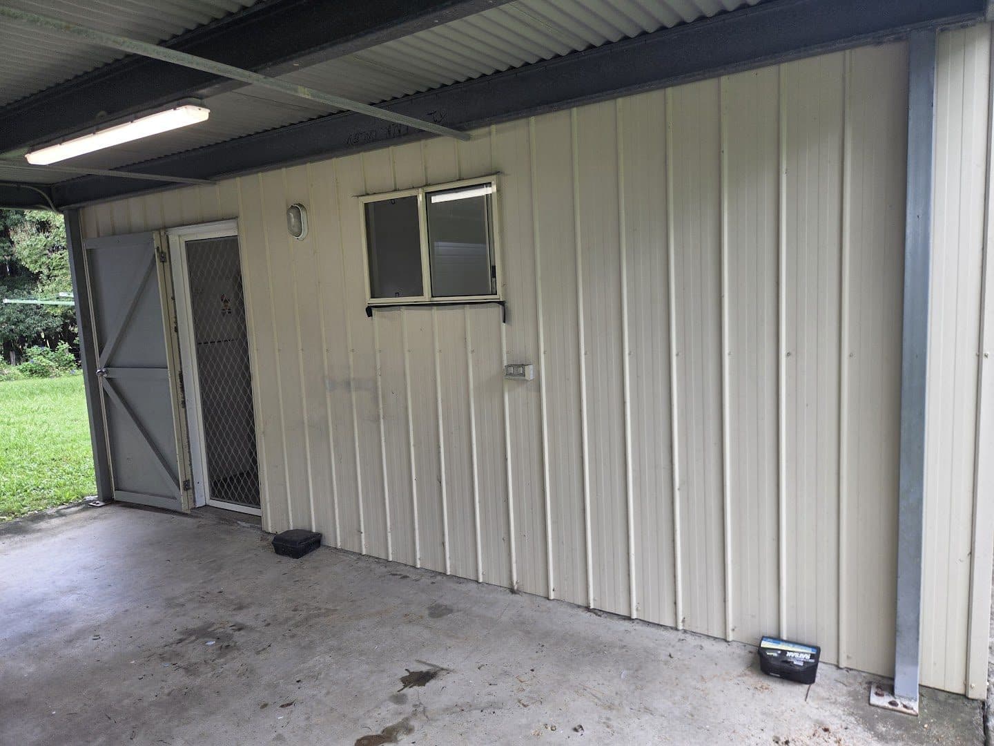 The same carport empty and swept after the clear-out