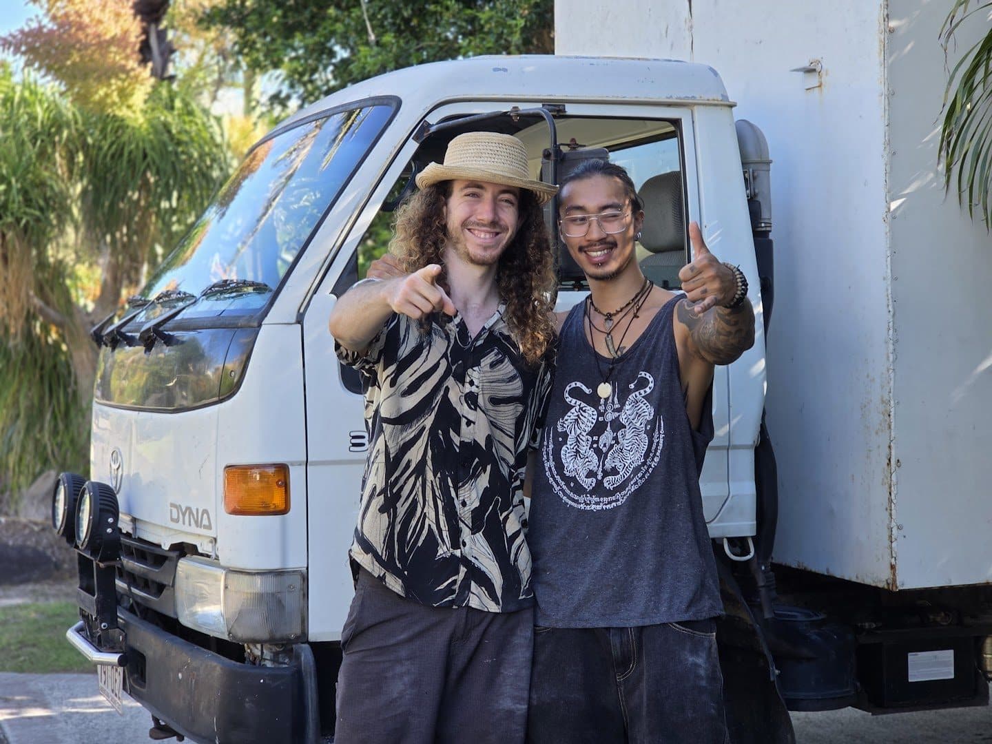 Mayan and Hugo in front of the truck cab, pointing and thumbs up