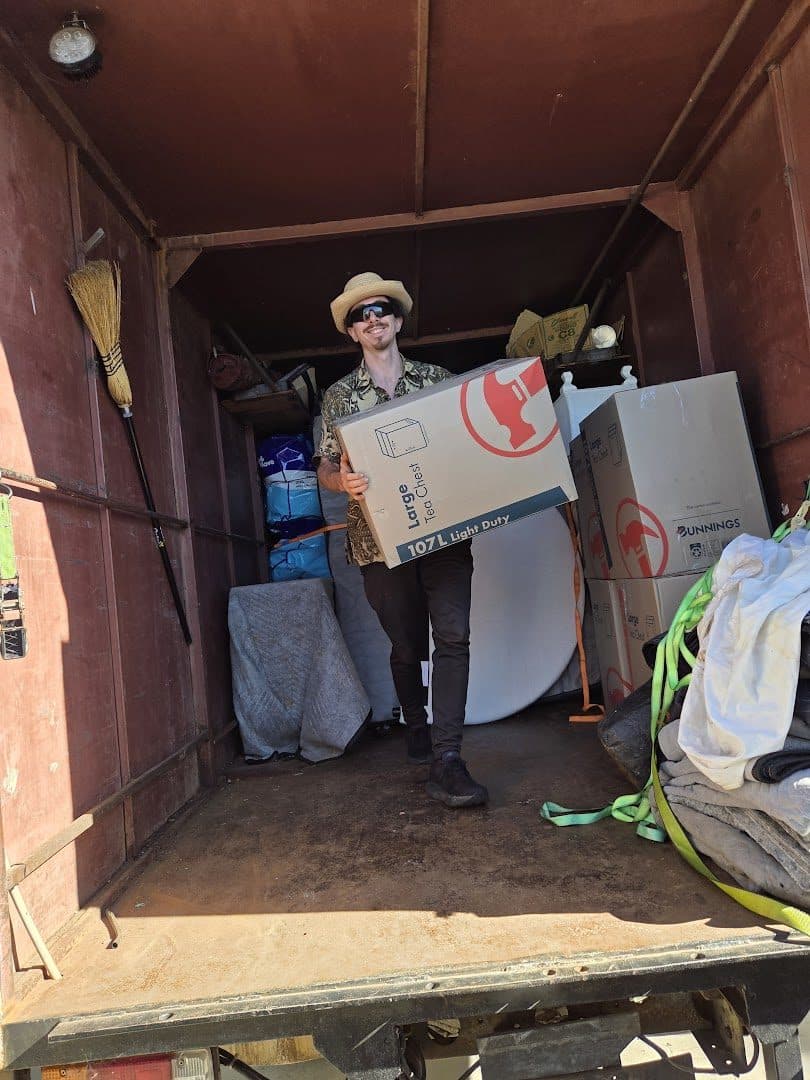 Mayan carrying a 107-litre tea chest box in the truck doorway