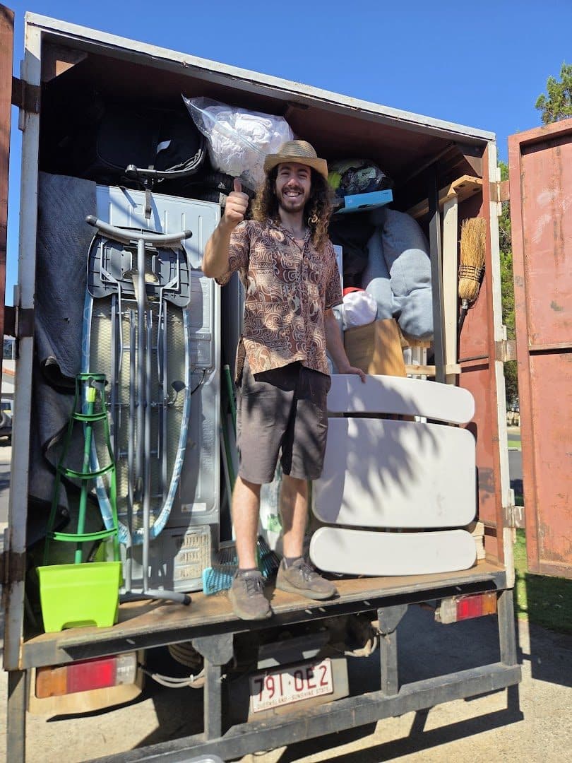 Mayan giving a thumbs up on the tailgate of a fully loaded truck